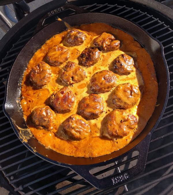 coconut curry pork meatballs simmering on the grill