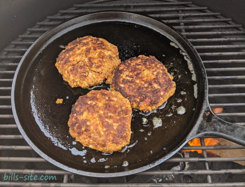 grilled salmon patties on a cast iron griddle