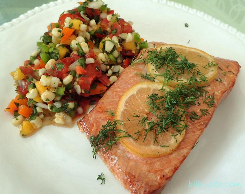Grilled cedar plank salmon fillets, one with mango salsa, the other with slices of lemon and dill. Good eats, the salmon is so moist and flavorful.