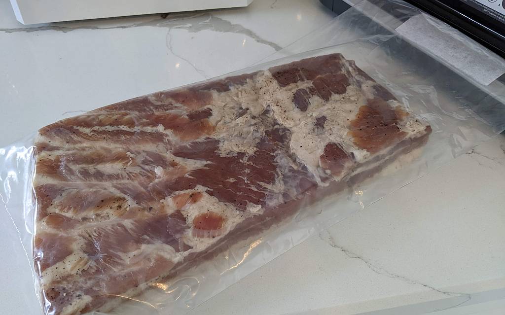 vacuum sealed UMAi dry age bag with pork belly for making pancetta