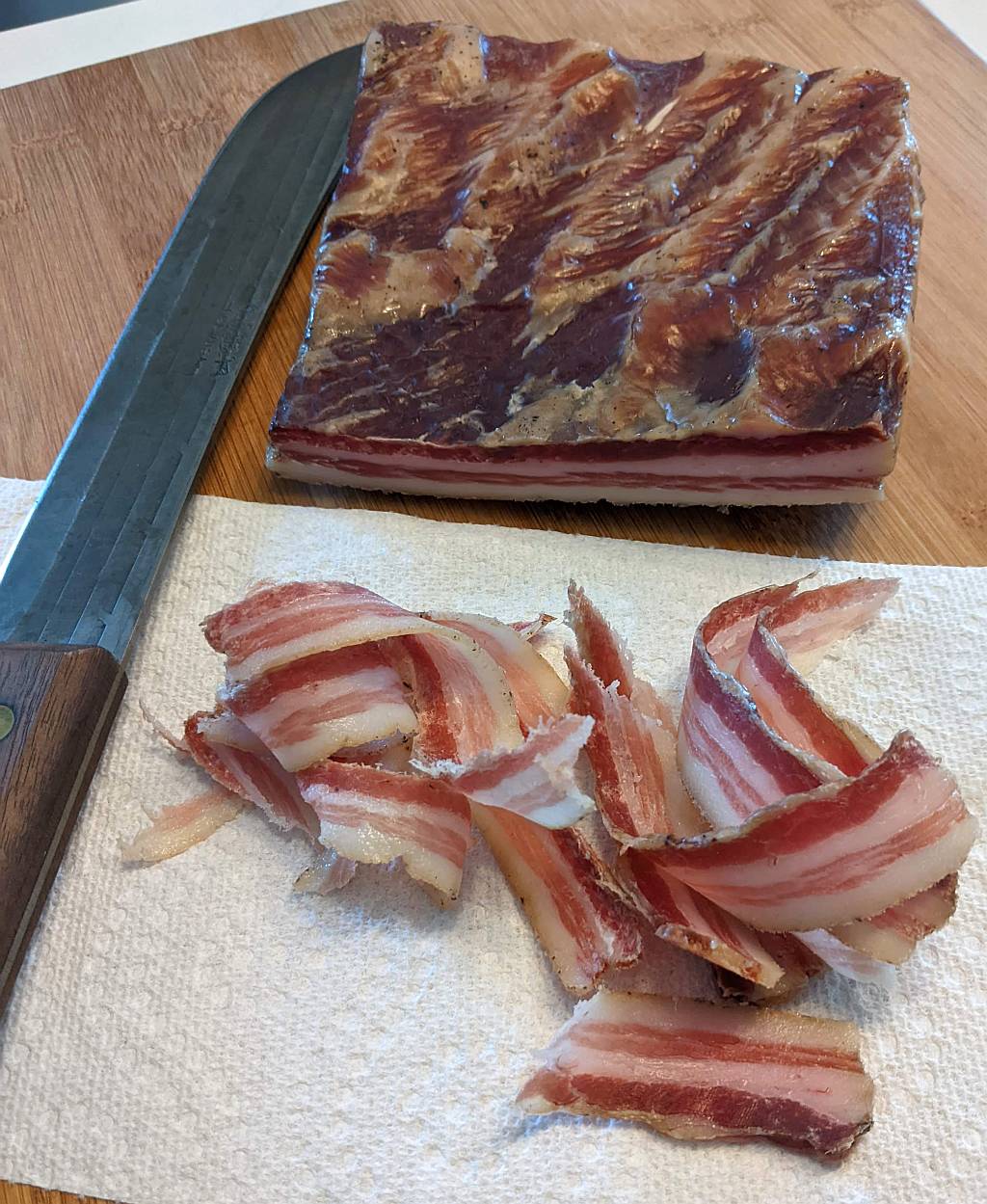 fully cured DIY pancetta on the cutting board ready for a taste test